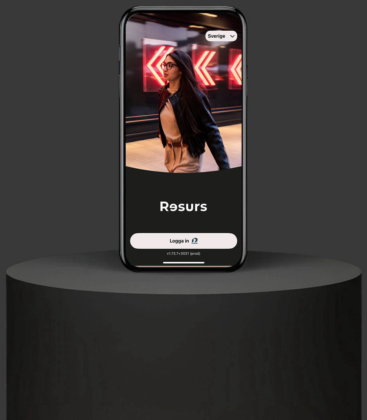 Mobil på podium. Mobilskärmen visar Resurs app.